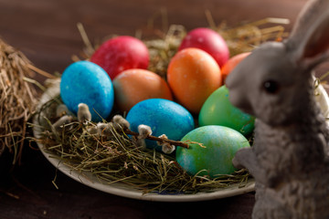 Easter bunny and a plate with colored eggs. Easter celebration concept.