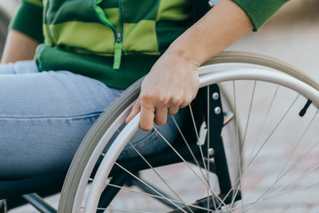 Close up of a young woman in a wheelchair while walking in a park on a sunny day. Recovery and...