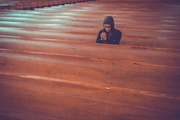 Young woman prayer's pray alone in church, People pray to God with folded hands, old wooden classic long chairs background