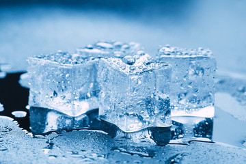 Pyramid of beautiful thawed ice cubes with drops of water