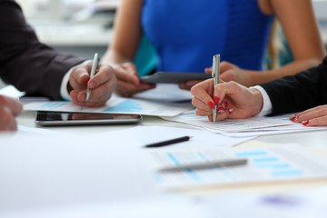 Silver pen lie on important paper at table with group of colleagues in background closeup. Paperwork job trade balance bank credit loan money invest payment irs commerce partnership concept