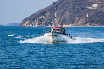 Fishing boat returning to port , Takamatsu city, kagawa, shikoku, japan