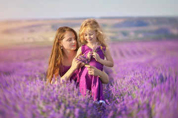Little girl and mother at meadow of lavender.