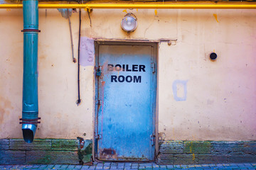 Old metal door with drips of paint and rust with the words "boiler room"