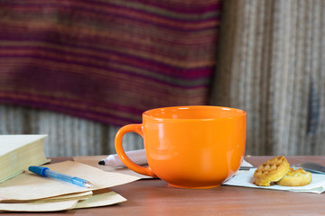 Cozy still life with an orange mug and a book