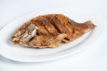 fried fish on white plate isolated on white background, top view