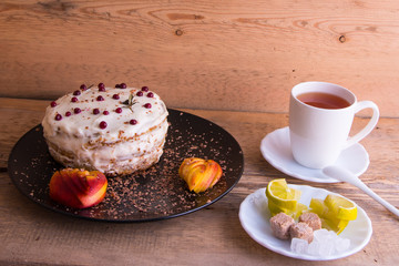 Obraz na płótnie Canvas Cake on a black plate, apple closeup, tea mug, plate with lemon, sahora, wooden background