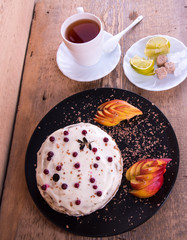 Cake on a black plate, apple closeup, tea mug, plate with lemon, sahora, wooden background