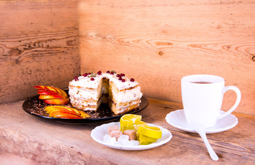 Cake on a black plate, apple closeup, tea mug, plate with lemon, sahora, wooden background