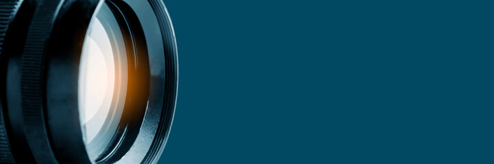 Photo or video camera lens on a blue background. Panoramic image, soft focus. The concept of news, media information