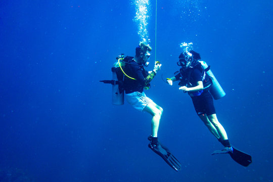 Scuba diver instructing student scuba diver safety stop