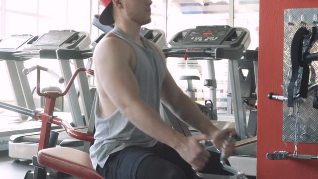 muscular Fit man training on row machine in gym, CrossFit concept. workout, exercises concept