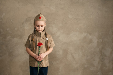 Little girl with flowers on the holiday of May 9, the day of victory in Russia