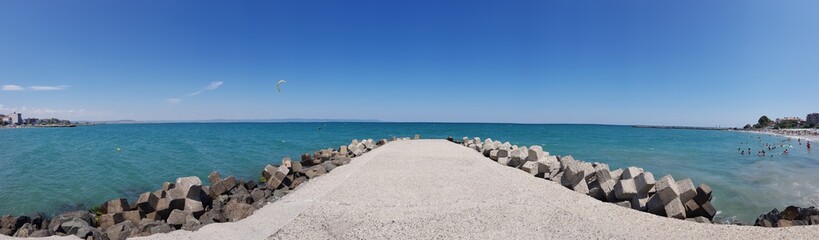 Panorama landscape view of pier  covered with breakwaters around, which protects the beach and the city from strong waves. 