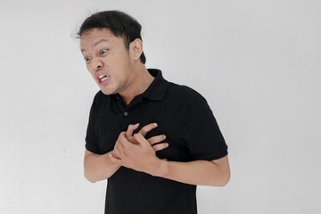Heart attack or broken heart of young asian man with hurt emotion wear black shirt.