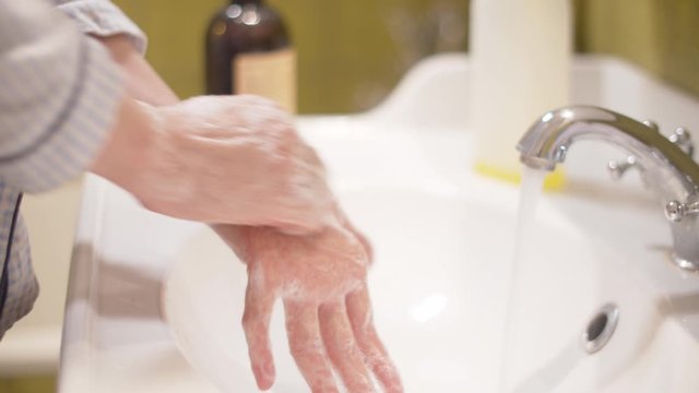 Woman scrupulously soaping her hands. Close up female hands covered by soapy foam in a bright bathroom. Hygiene during epidemic. Covid-19 pandemic