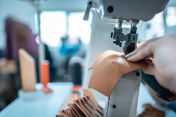 woman work with sewing machinery on shoe factory