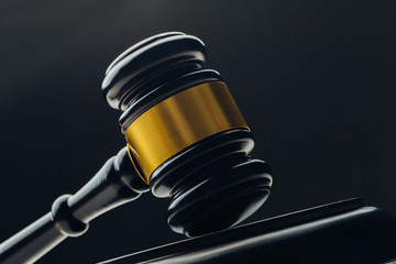 Judge's gavel with gold metal on a black table. Concept of law