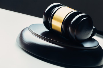 Judge's gavel with gold metal on a black table. Concept of law