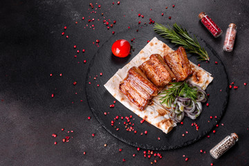Fried ribs with rosemary, onion, sauce on a concrete background