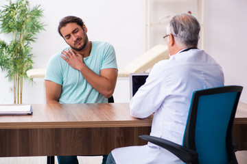 Injured young man visiting old doctor