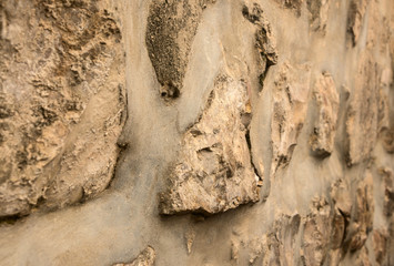 Ancient wall folded of natural rough stones, perspective view.