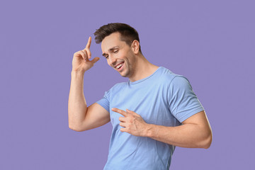 Cool young man dancing against color background