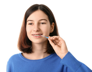 Teenage girl with dental braces and brush on white background