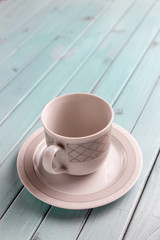 White porcelain coffee Cup on a turquoise wooden table. Still life in pastel colors.