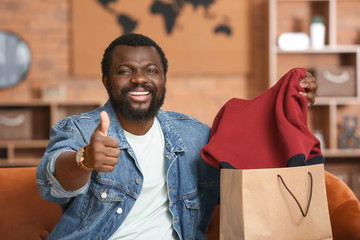 African-American man with received new clothes at home