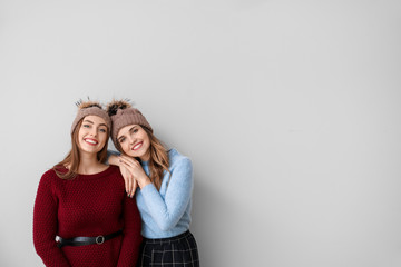 Young women in warm sweaters on light background