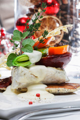 A modern dish with zander and vegetables. Table setting in luxurious restaurant.