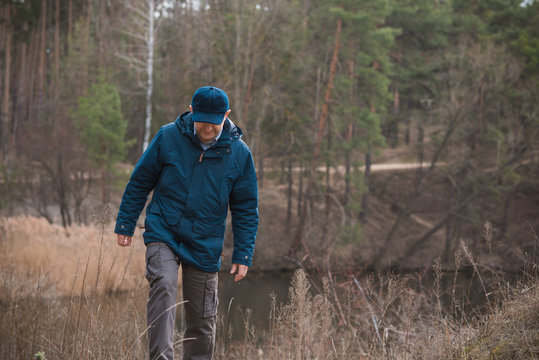 Mature man rest at nature in forest and lake, senior man lifestyle