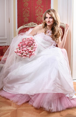 Fototapeta premium Beautiful young blonde bride with huge bouquet of pink tulips.