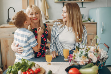 F in a kitchen. Blonde in a white t-shirt. Woman with vegetables