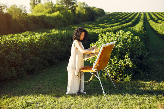 Woman artist painting with oil. Paints in a field