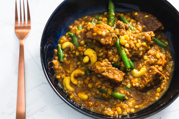 plant-based food, spicy apricot curry with mixed vegetables and vegan sausages