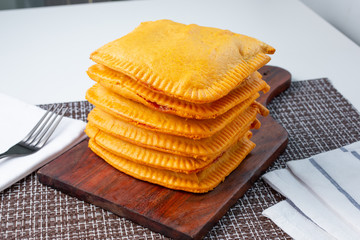 A view of a stack of Jamaican patties, in a restaurant or kitchen setting.