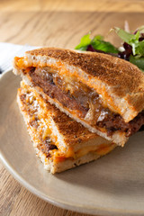 A view of a patty melt sandwich in a restaurant or kitchen setting.