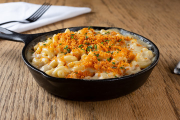 A view of a skillet of macaroni and cheese, in a restaurant or kitchen setting.