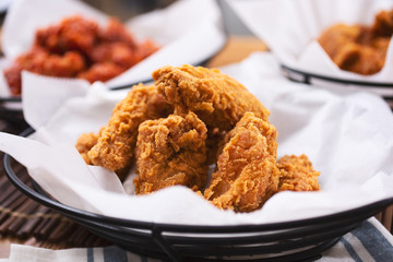 A view of baskets with a variety of Korean fried chicken in a restaurant or kitchen setting.