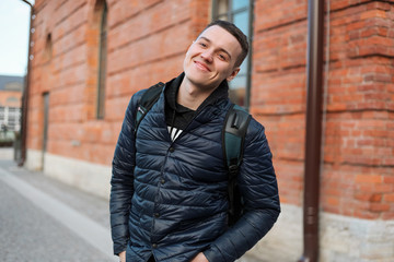 Handsome young fashion model posing on city streets. Lifestyle c