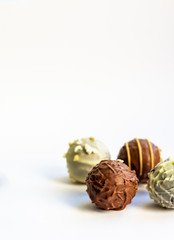 an assortment of belgian chocolates in white and milk chocolate, copy space, confectionery concept