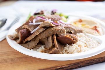 A view of a plate of beef shawarma, in a restaurant or kitchen setting.