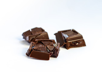 pieces of dark chocolate on a white background, the filling flowing from a broken chocolate, ugly...