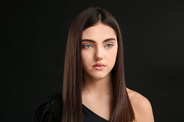 Fototapeta premium Young woman with beautiful straight hair on dark background