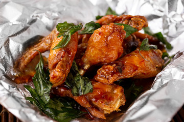 A view of a basket of Asian glazed chicken wings, in a restaurant or kitchen setting.