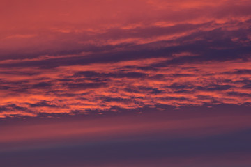 Idyllic sunshine sky of lush lava color clouds in sunset sky as abstract texture, background.