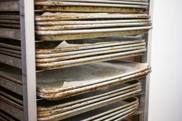 A view of a rack full of pastry oven trays, in a bakery setting.