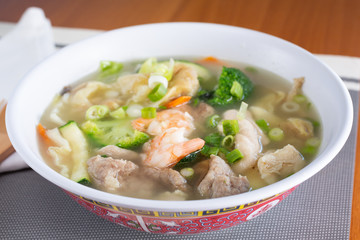 A view of a big bowl of Chinese wonton soup in a restaurant or kitchen setting.